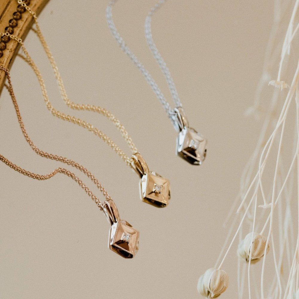 Gold necklaces with pendants on a neutral background