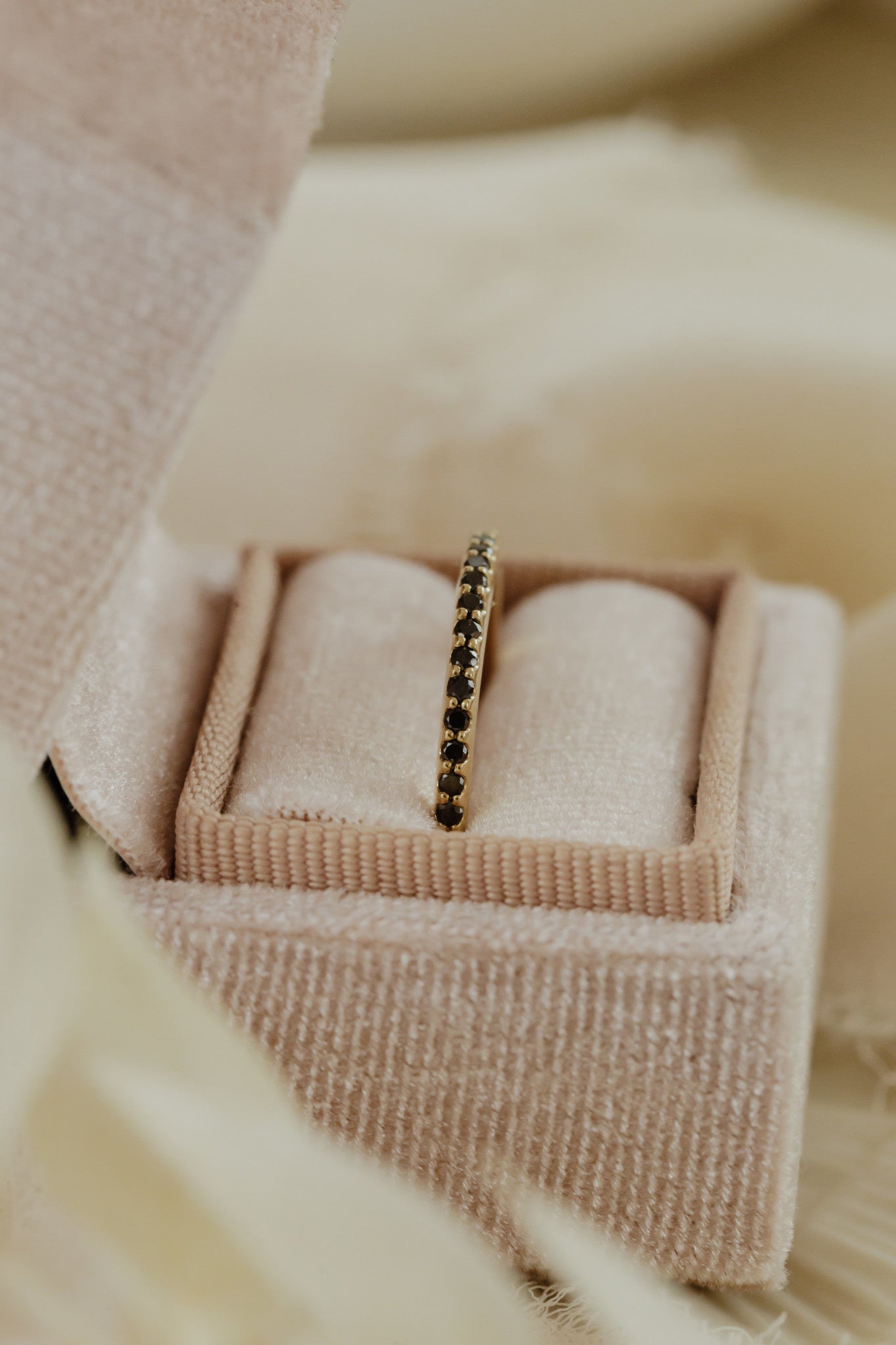 The Jenna Black Diamond Band in 14k yellow gold placed in a Sarah O Jewelry velvet ring box