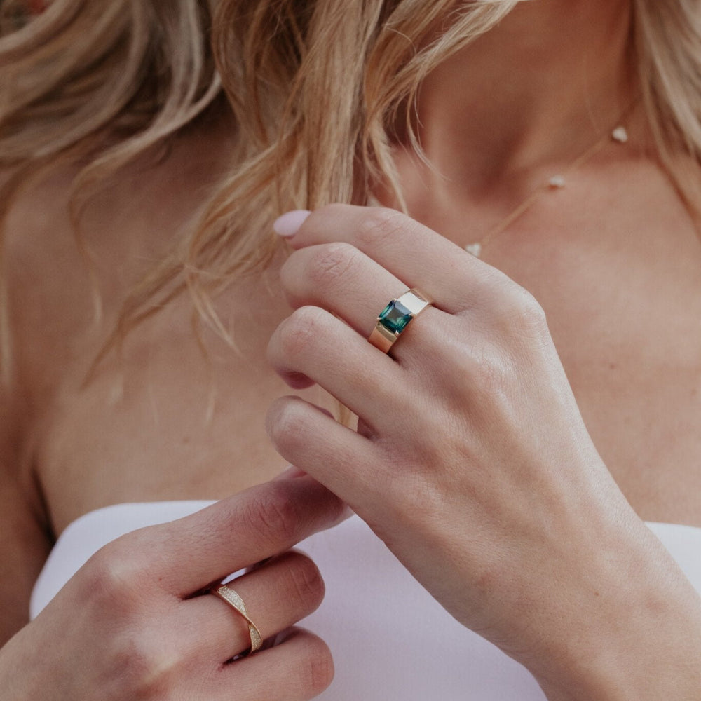 Close-up of two hands with rings on a blurred background