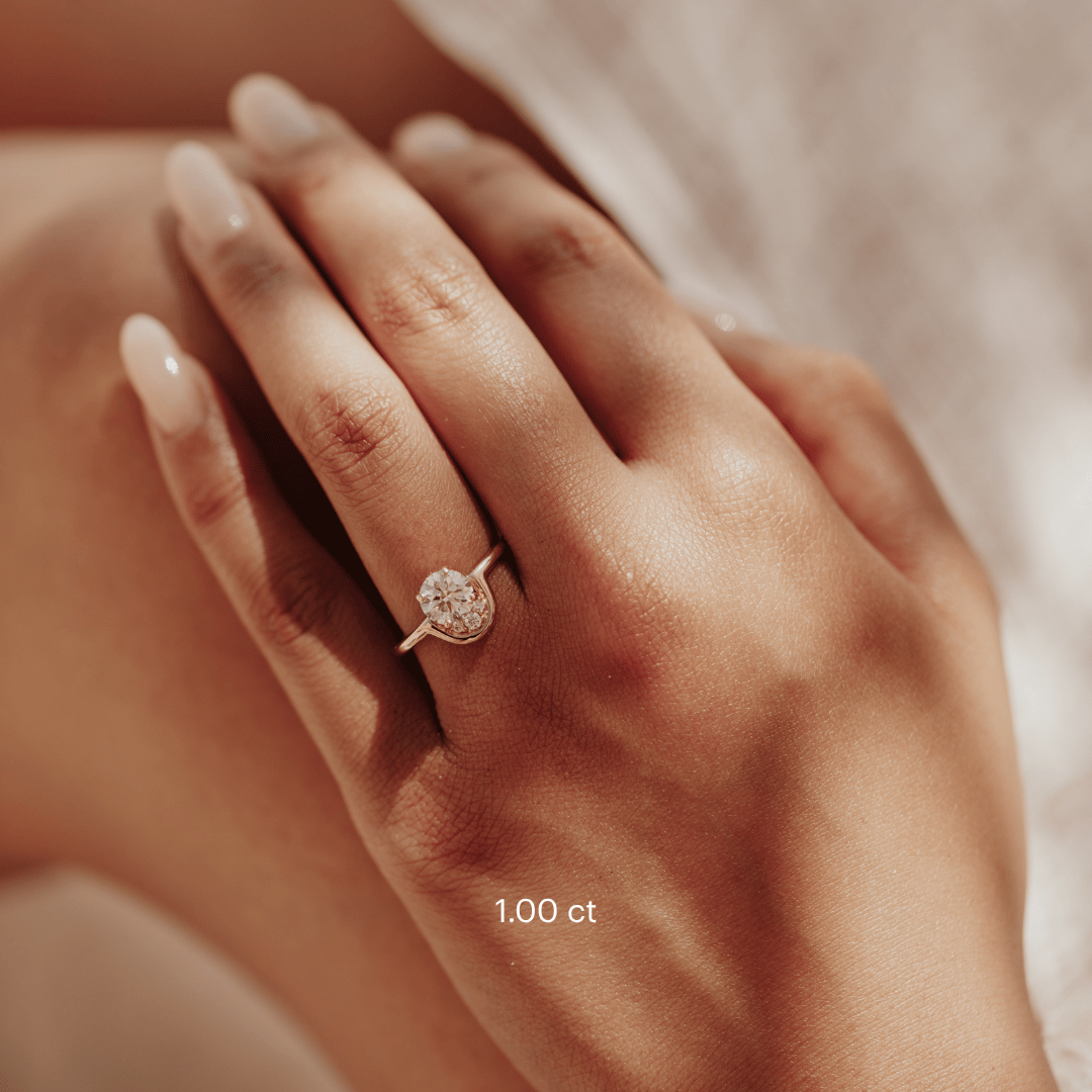 The Palma Round Ring in 14k yellow gold featuring a lab-grown round diamond center stone with round diamond arc accent, worn on the ring finger.