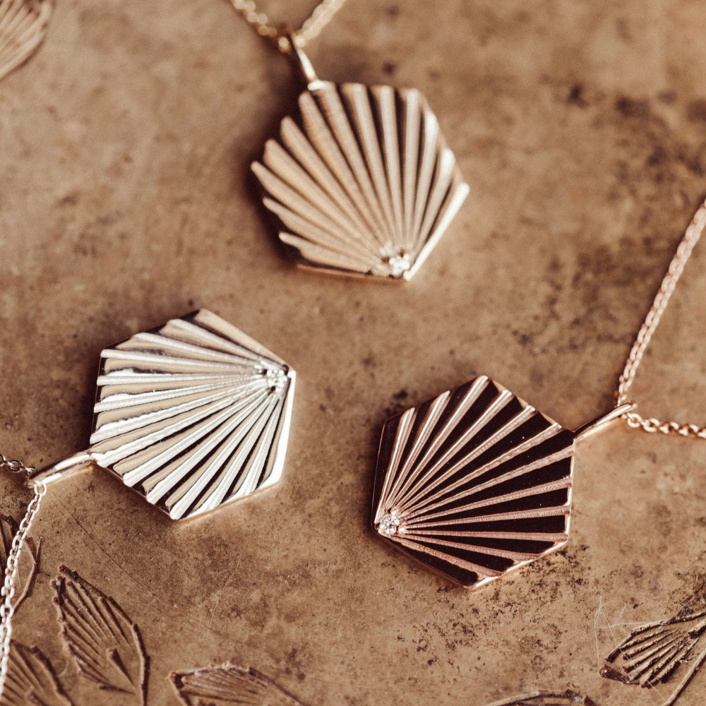 Gold shell-shaped charms on a textured surface