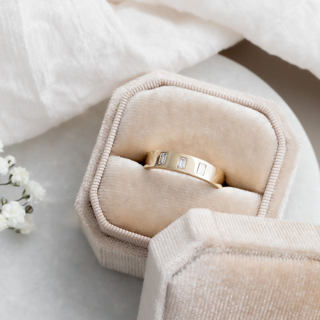 The Jaden Three Baguette Wedding Band in 14k yellow gold in a Sarah O Jewelry velvet ring box